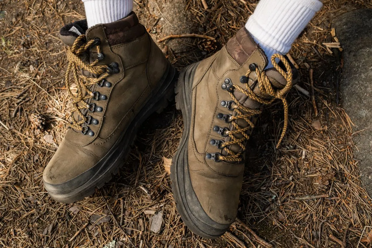 Close view of hiking boots and socks on a forest floor