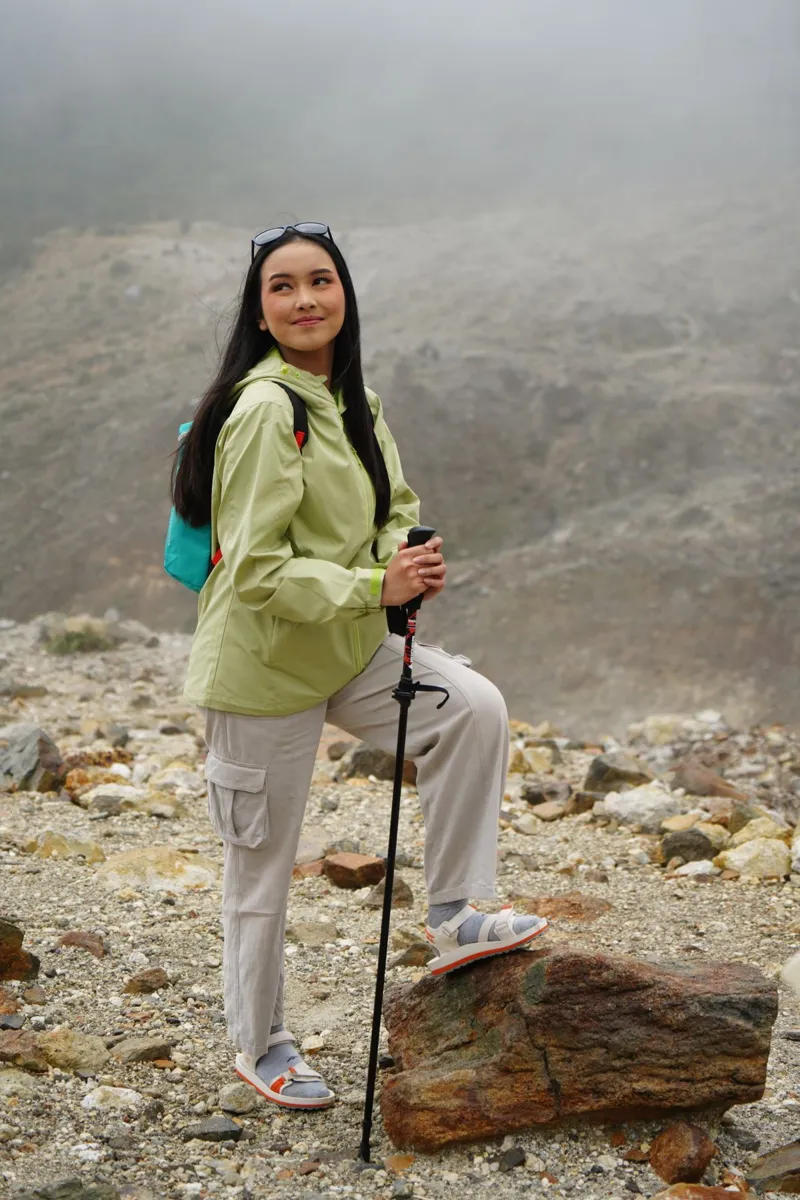 Hiker with trekking poles on a misty mountain trail